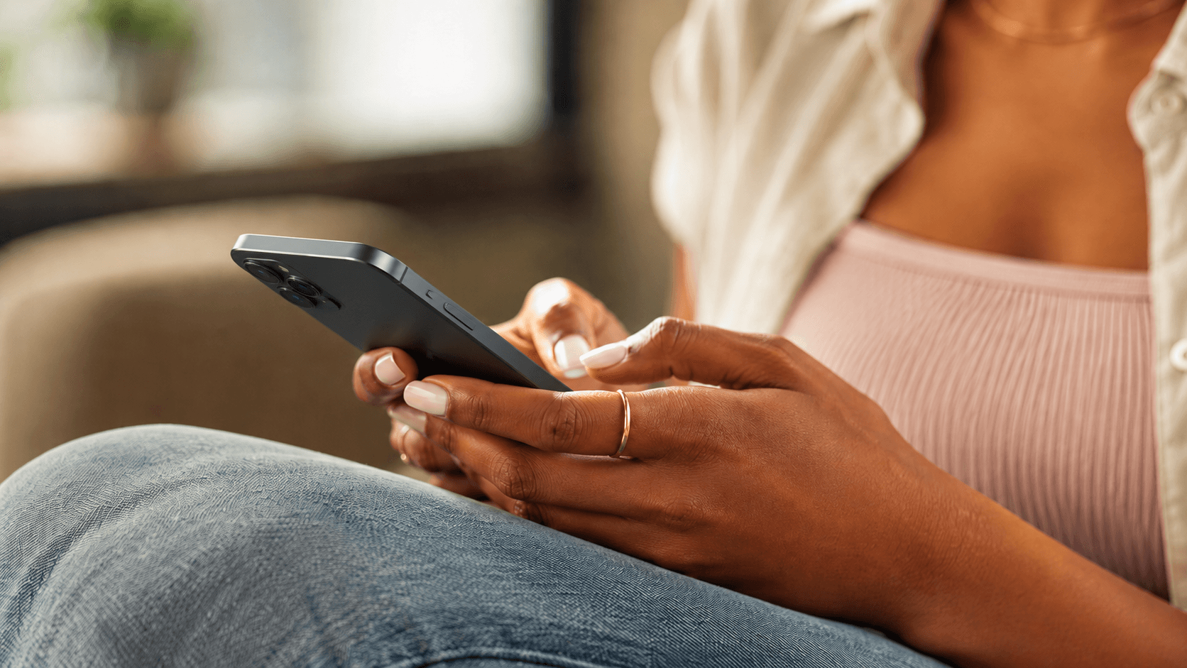 Une personne assise consulte son smartphone.